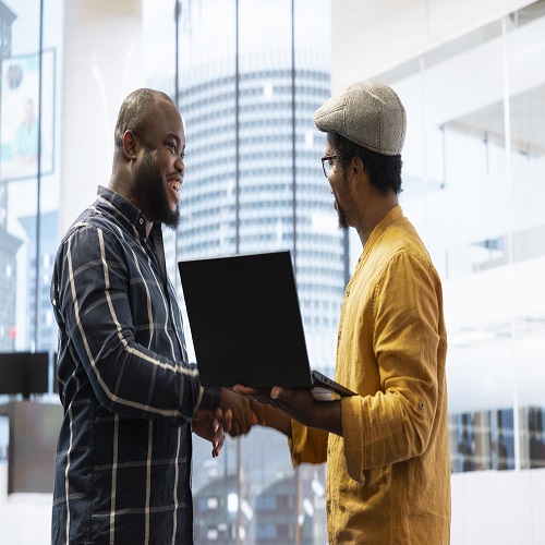 Business professionals collaborating with laptop in office